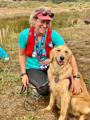 Golden Retriever and Dog Mom kneeling down in a field at wildfire basecamp