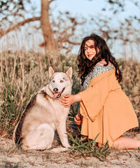 Dog Mom and Rescue Husky kneeling down in a field