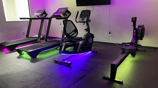 Cardio machines with colorful lighting underneath.