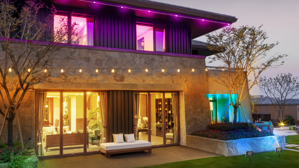 Two story home with colorful outdoor lights.