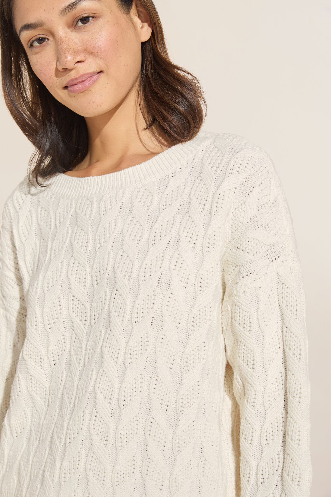 Model wears Cable Knit Recycled Sweater Crewneck in Ivory.