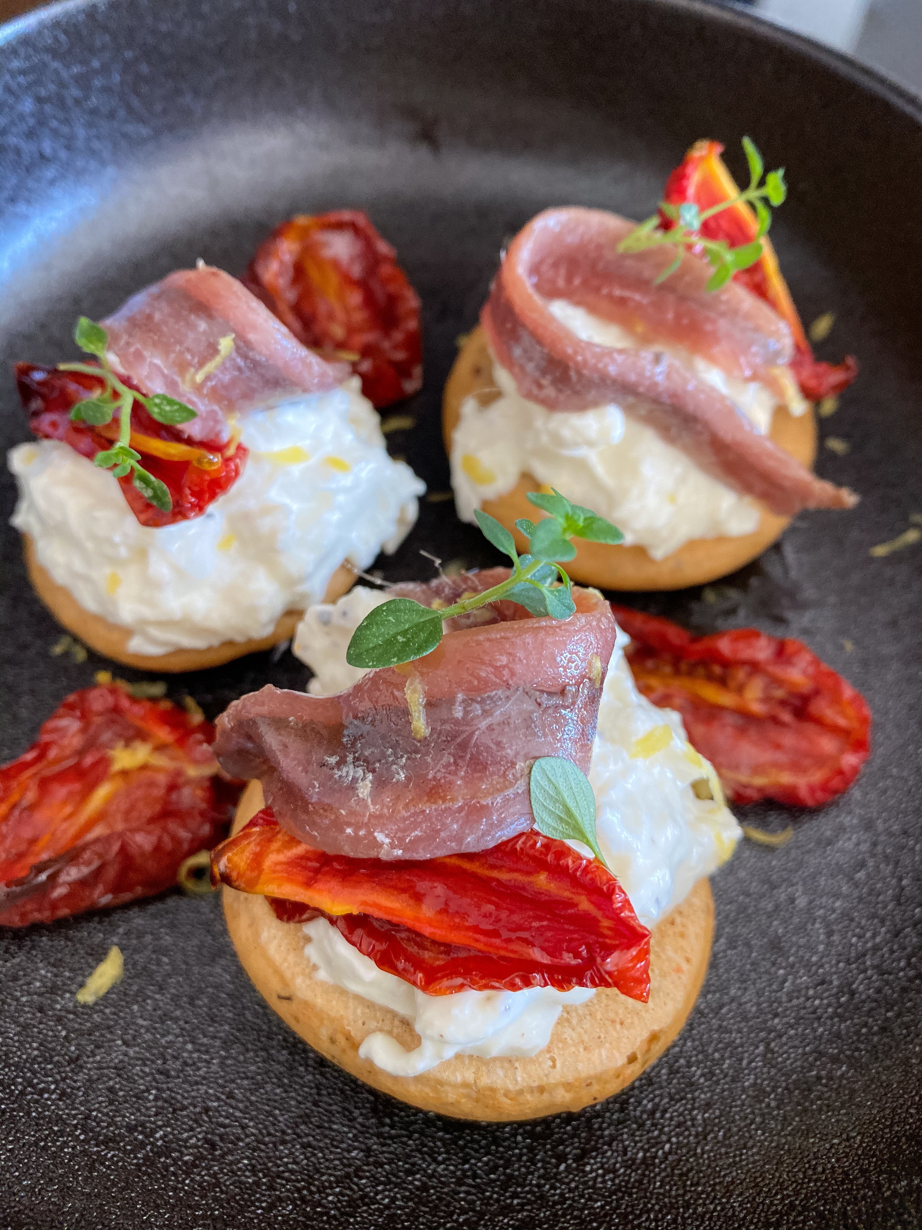 Bruschette rustiche con burrata, pomodori, alici e limone