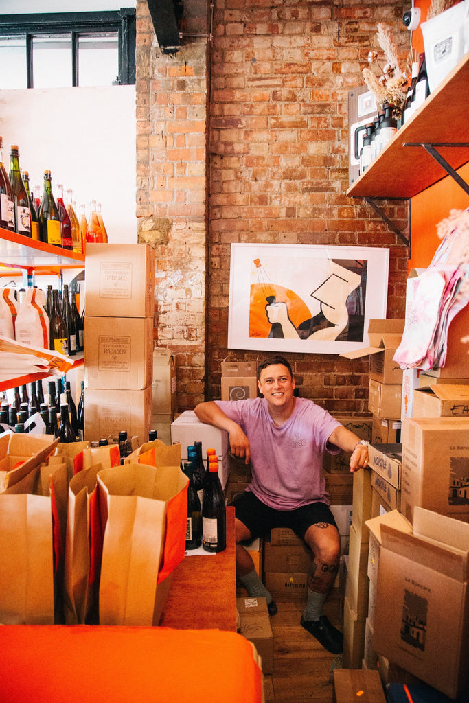 Brodie Meah in the Top Cuvee Shop surrounded by boxes of wine