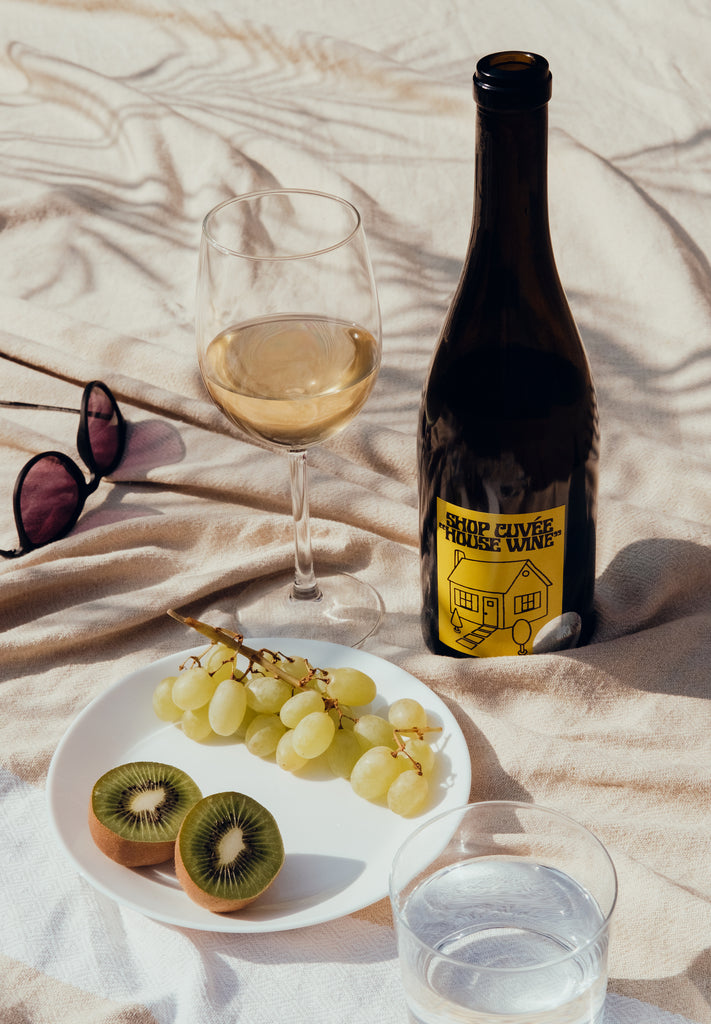 Shop Cuvee Wine on a picnic blanket with a plate of fruit