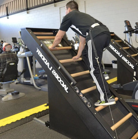 Jacobs Ladder in the gym with a man using it and other equipment in background