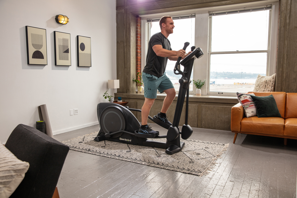 Sportsart E80C in home residential elliptical in a living room with male user