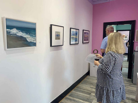 Exhibition room with people looking at art