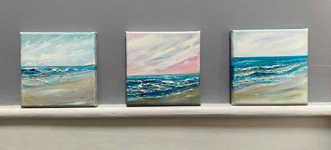 3 square seascape paintings on a ledge