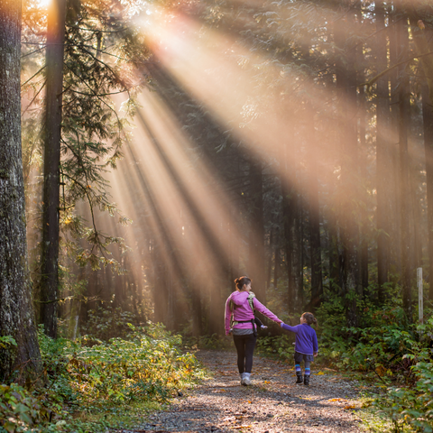 Mom and daughter walking in forest