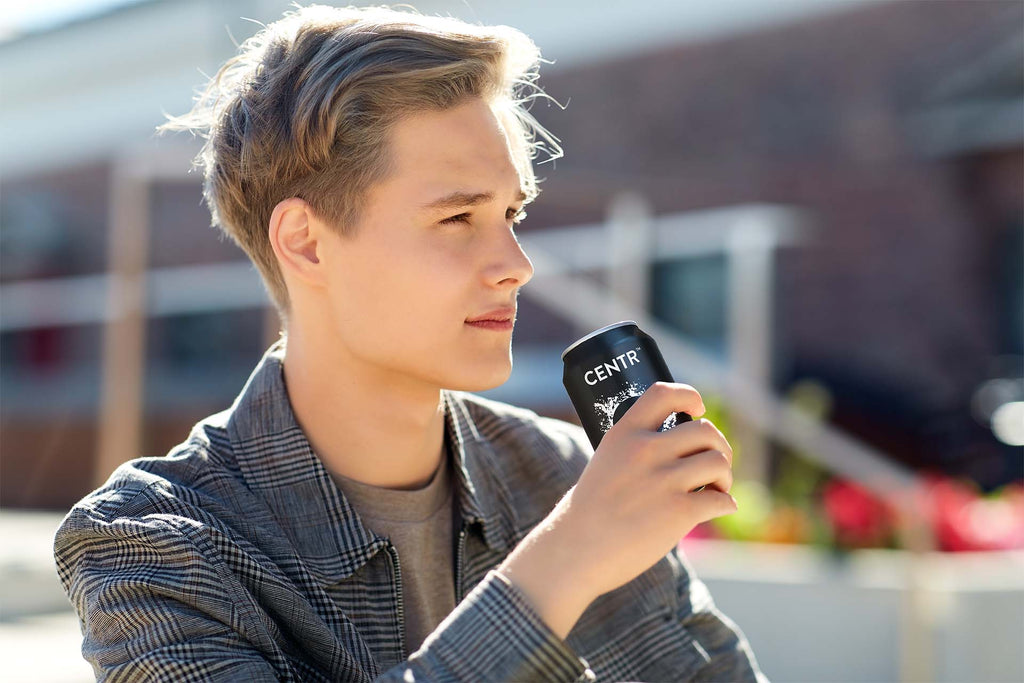 man drinking cbd drink from a can