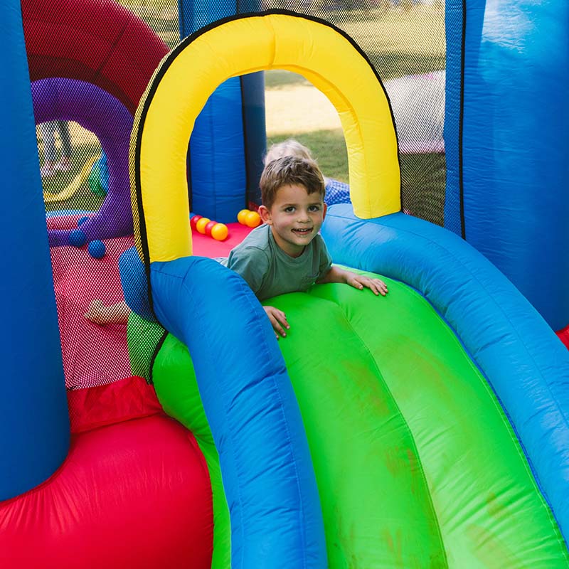 kid-wise-lucky-rainbow-bounce-house-slide-close-up-with-a-boy-smiling