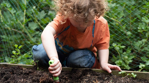 boy digging in soil by himself