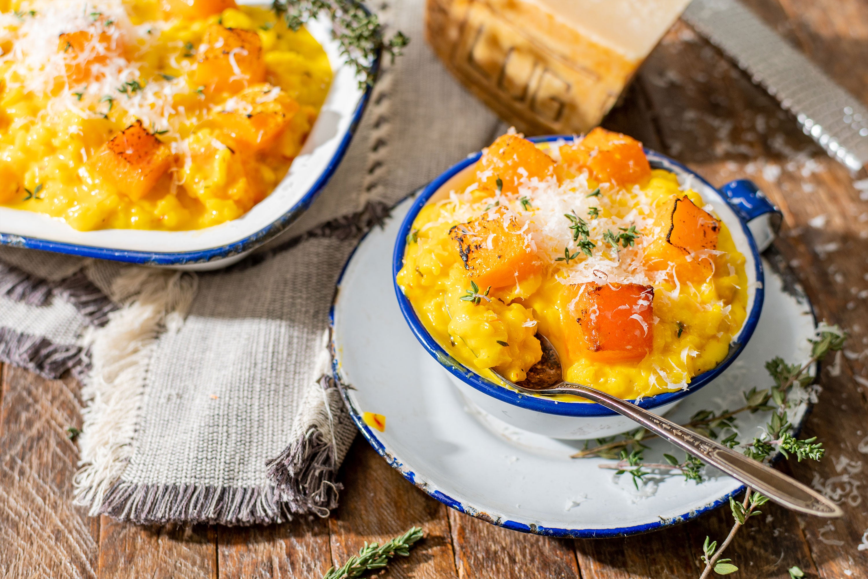 Saffron & Squash Risotto in bowls with cheese and herbs