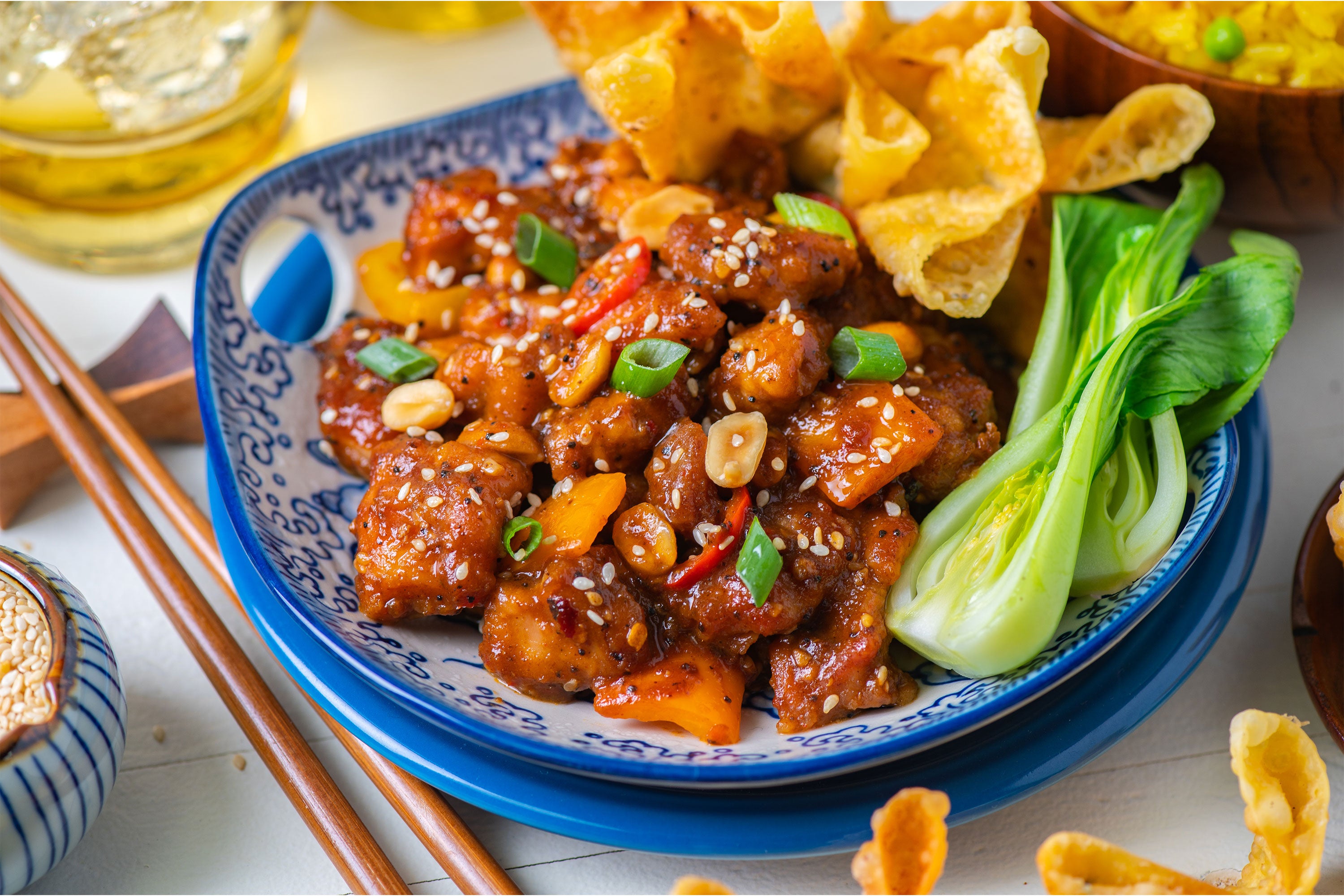 Close up of kung pao chicken plate with bok choy and wantons