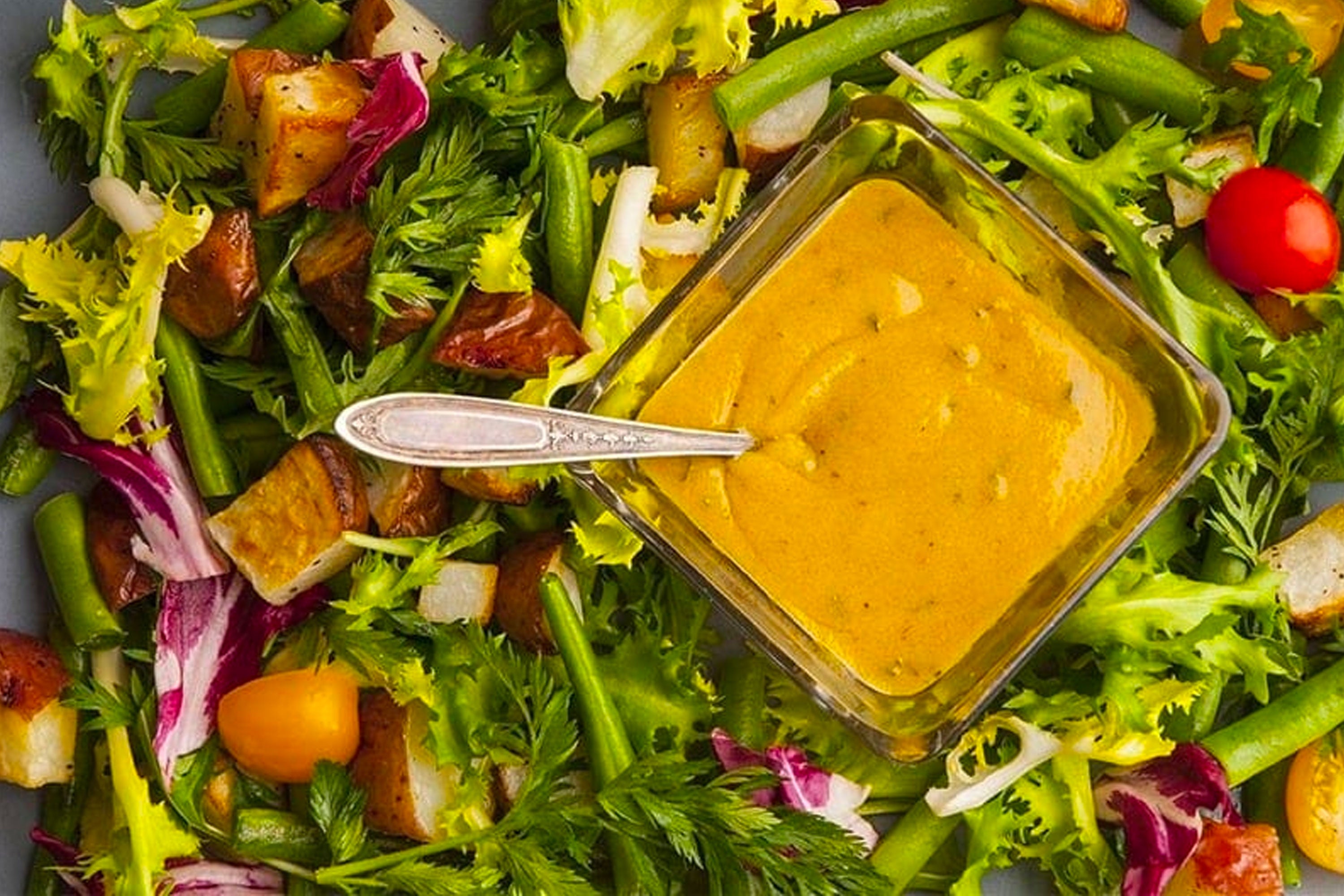 Salad with diamond container of Spiced Honey Mustard Dressing