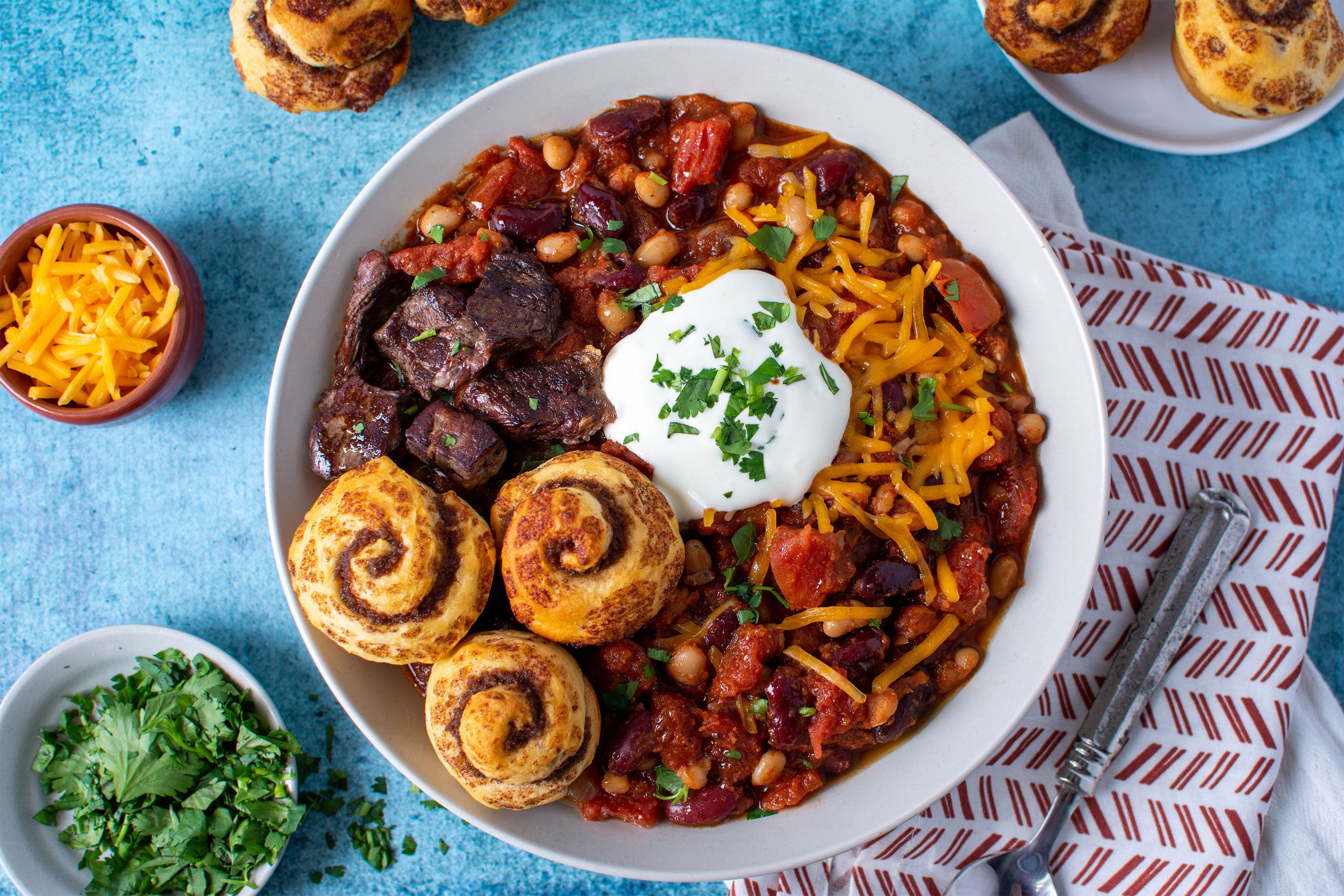 Big Red Bison Chili with toppings and mini cinnamon rolls.