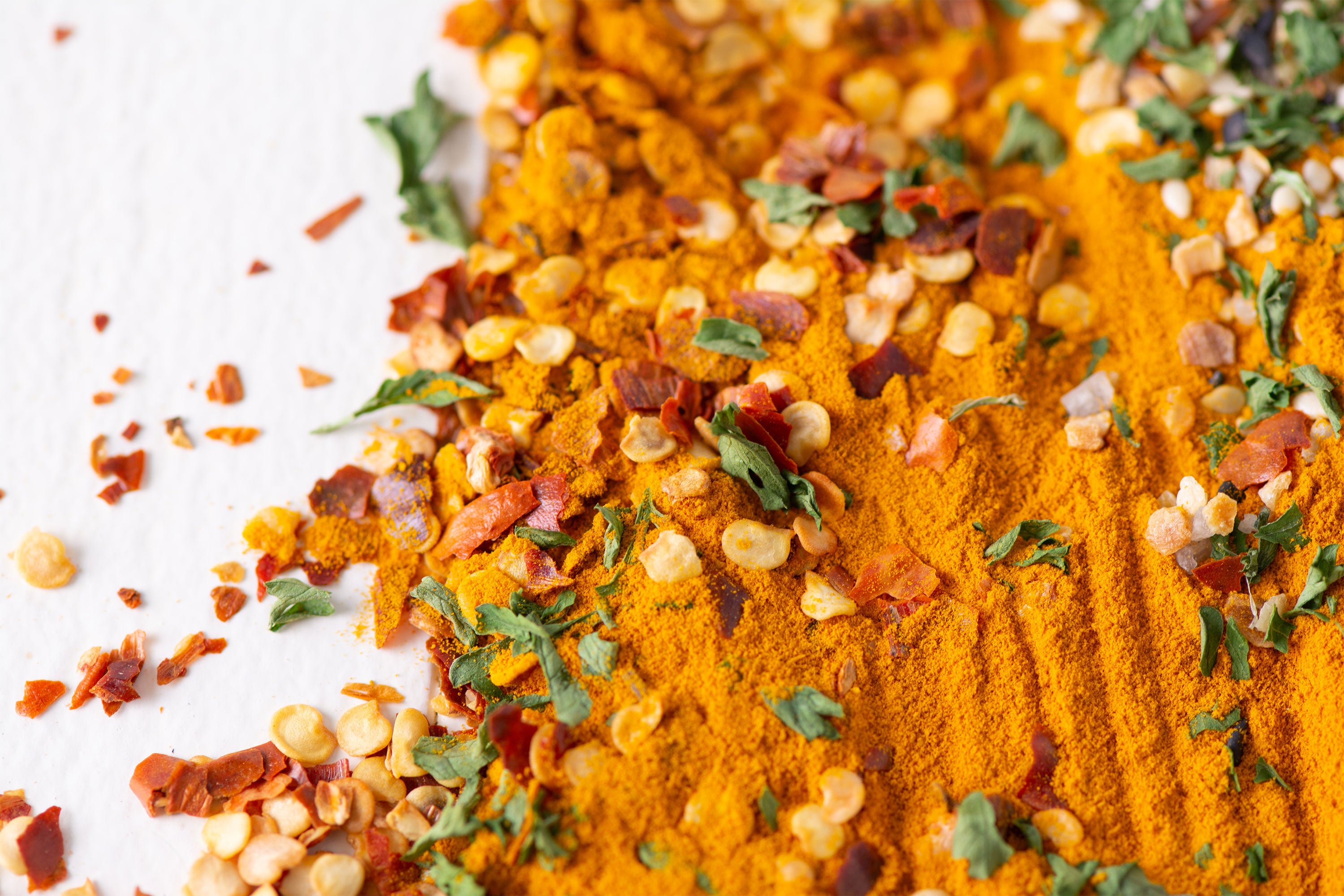 Close up of turmeric, chile flakes, and parsley