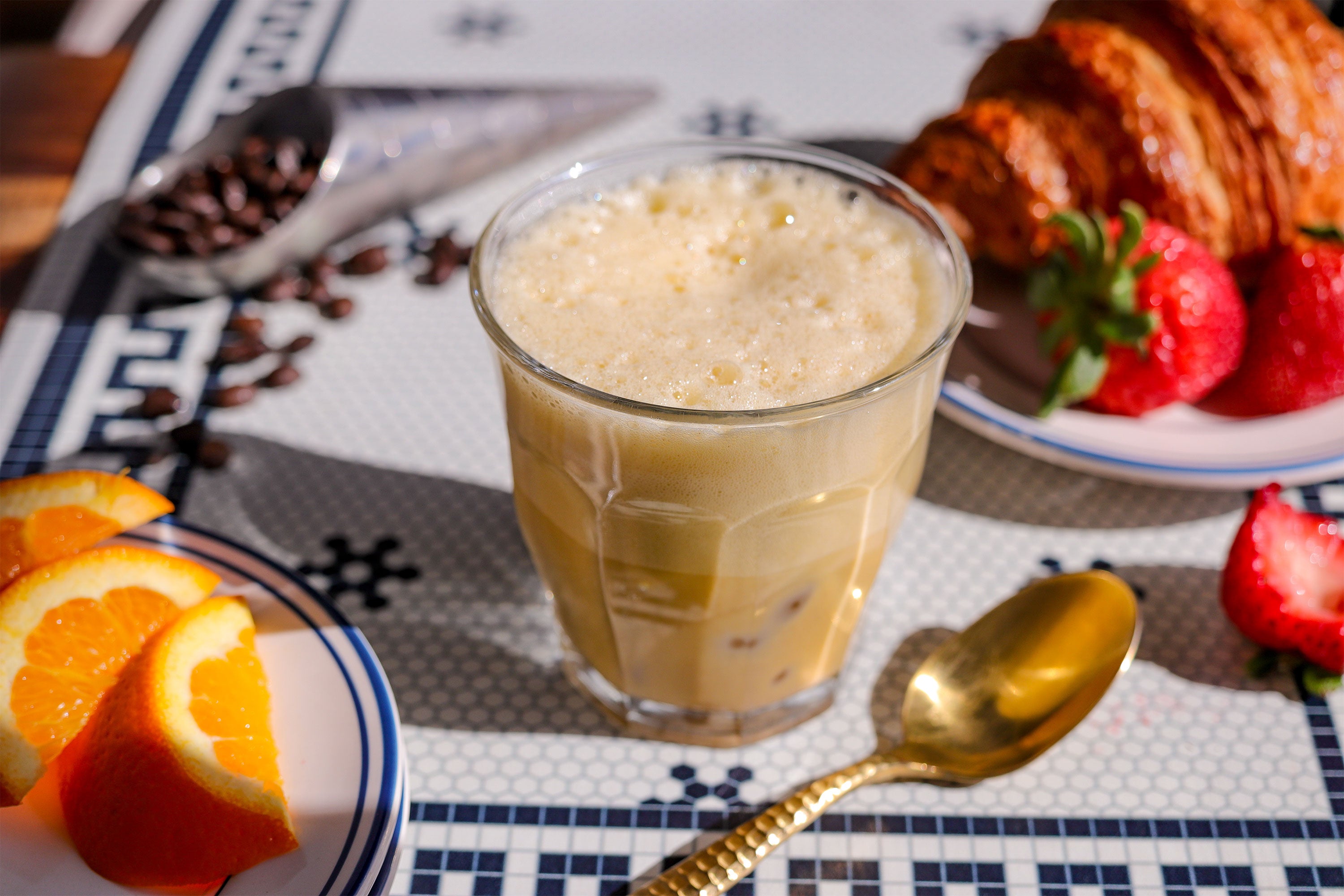 Iced Cream Coffee on colorful table with fruit and croissant on the side