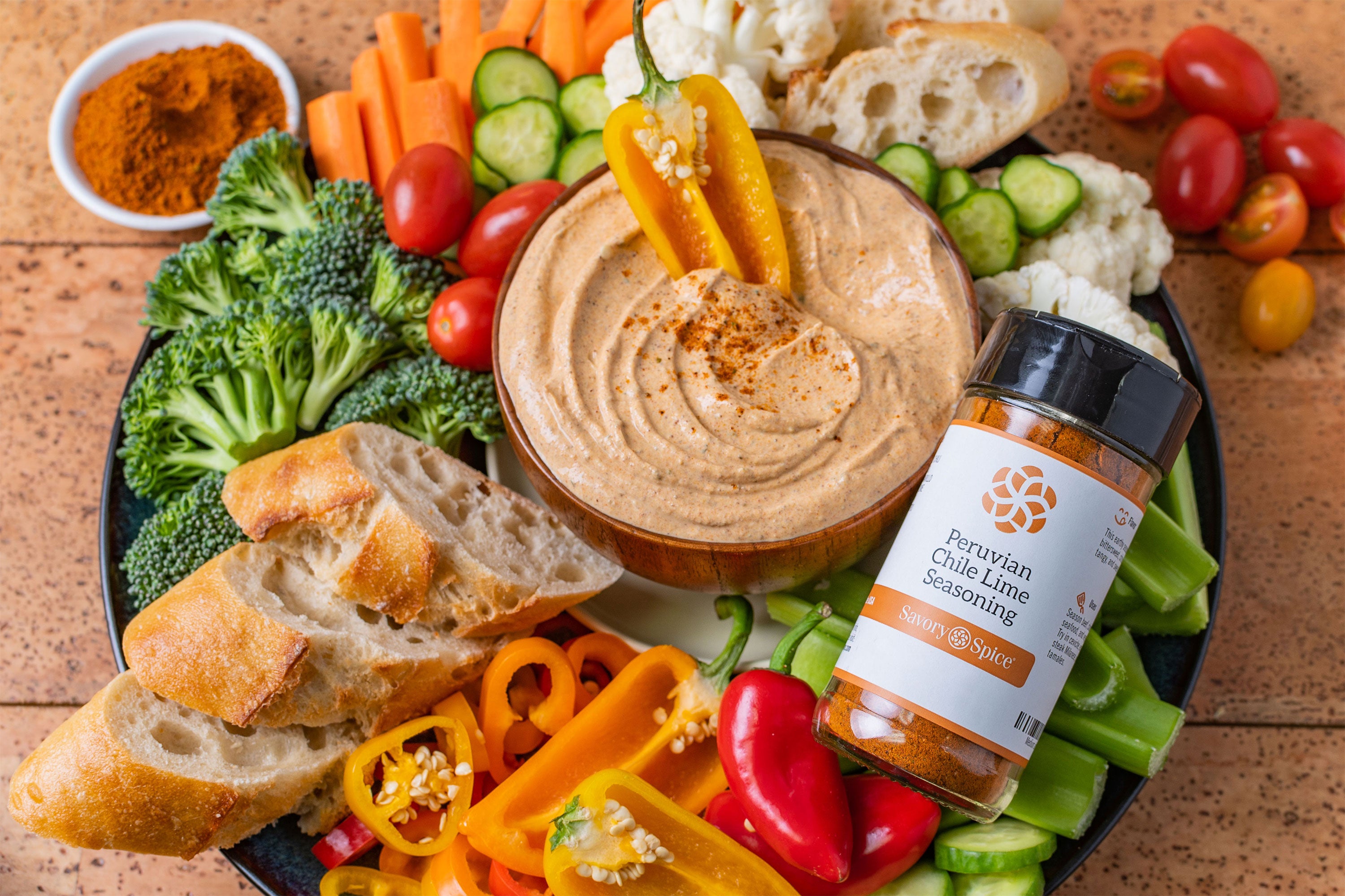 Crudité platter with Peruvian Chile Lime Seasoning jar on the right and dip in center