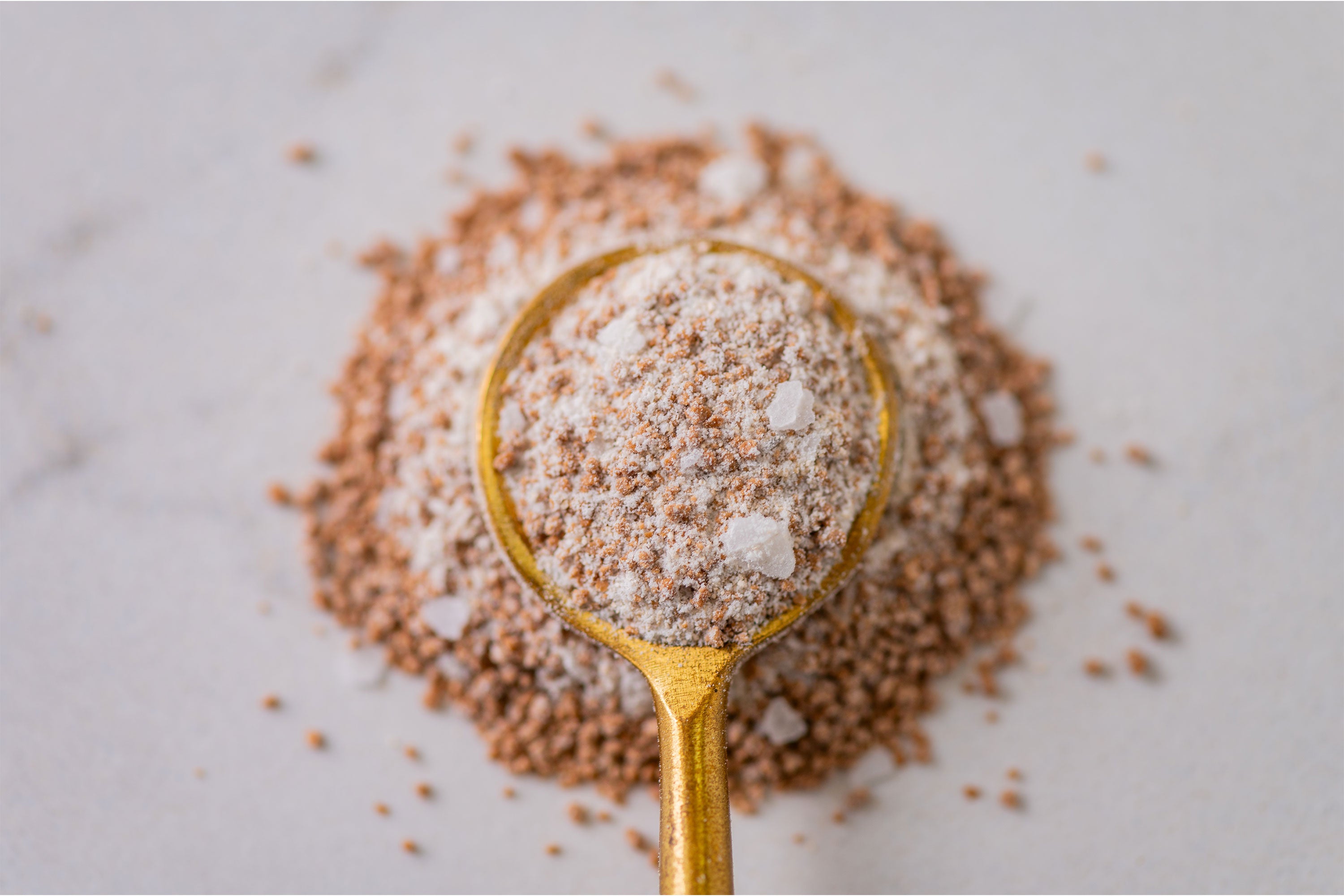 Gold spoon with close up of Salted Caramel Spice granules