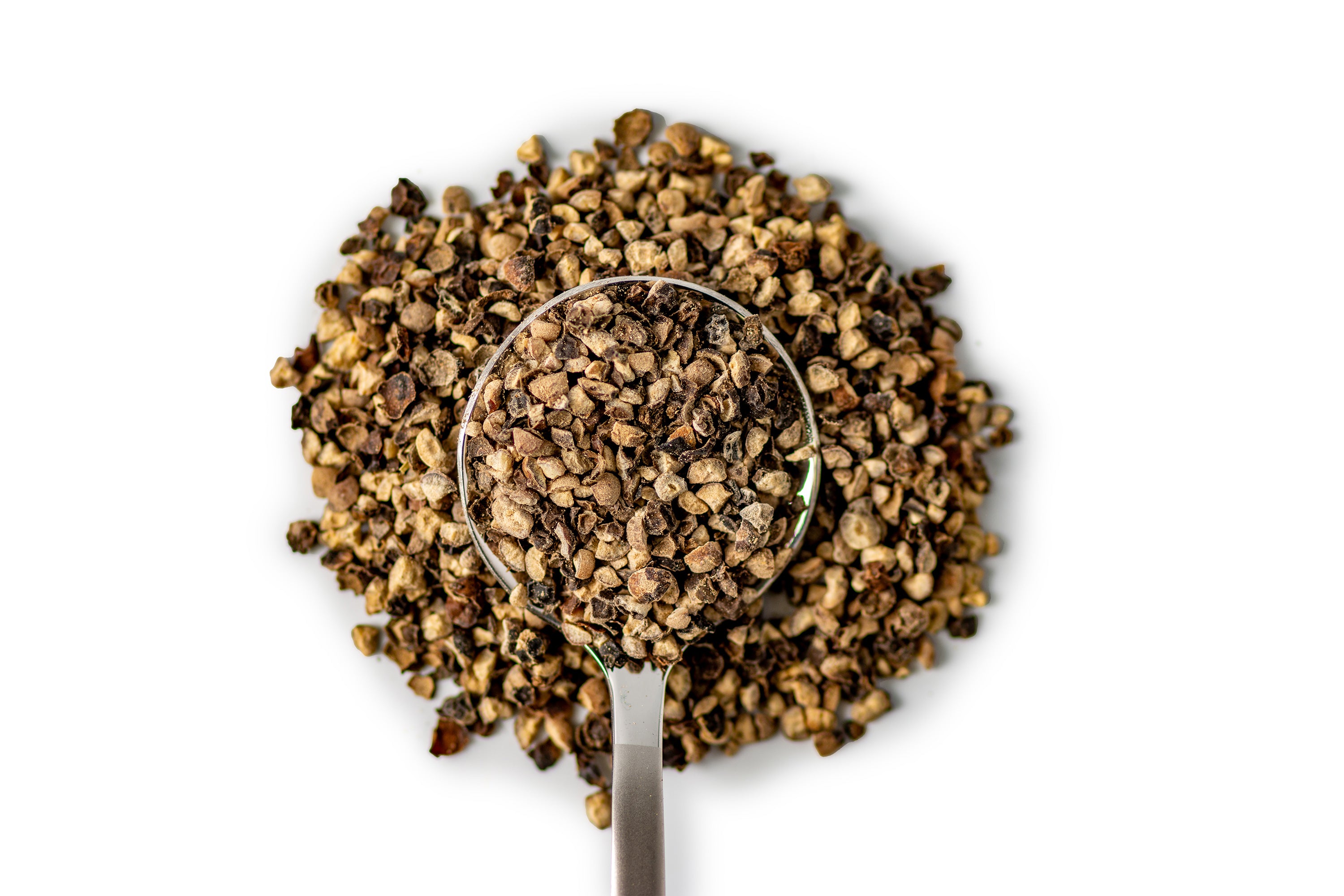 Close up of a spoonful of coarse black pepper