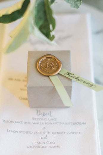 gold wax seal with monogram on wedding favors