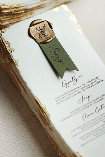 gold monogrammed wax seal on wedding menu