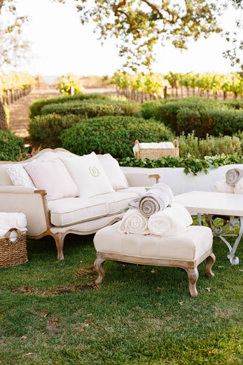 outdoor wedding lounge with vintage furniture and monogrammed decorative pillows