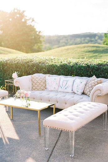 outdoor wedding lounge with vintage furniture and decorative pillows