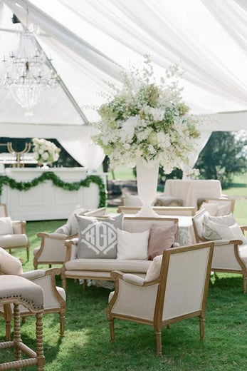 outdoor wedding lounge with a monogrammed throw pillow on vintage furniture