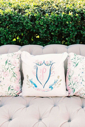 watercolor wedding crest monogram design printed on a white throw pillow