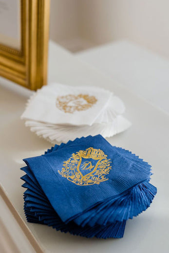 dark blue paper cocktail napkins with gold wedding monogram crest