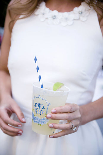 monogrammed frosted plastic cocktail cup with wedding monogram crest held by the bride