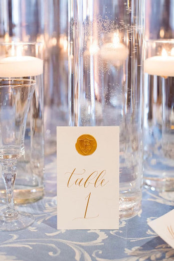 table number with gold calligraphy and wax seal