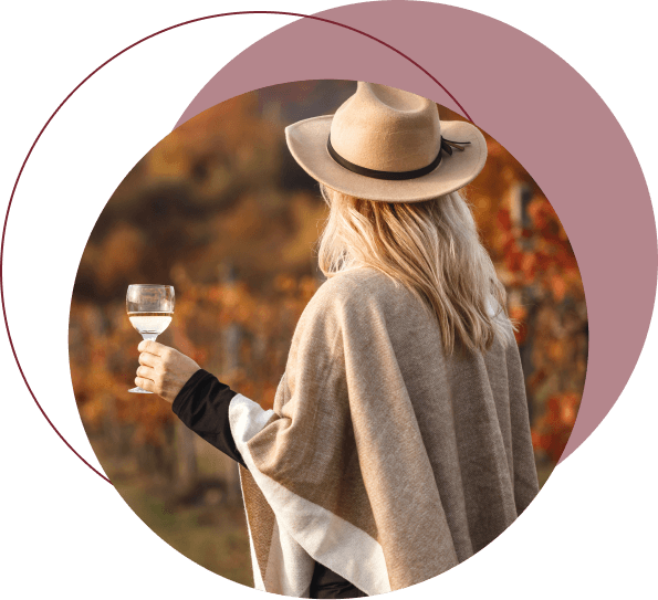 Woman enjoying a glass of wine at a scenic vineyard.