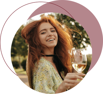 A radiant woman turning back to the camera, smiling warmly, while delicately holding a glass of fine wine, illustrating the joyful experience of tasting exquisite vintages.