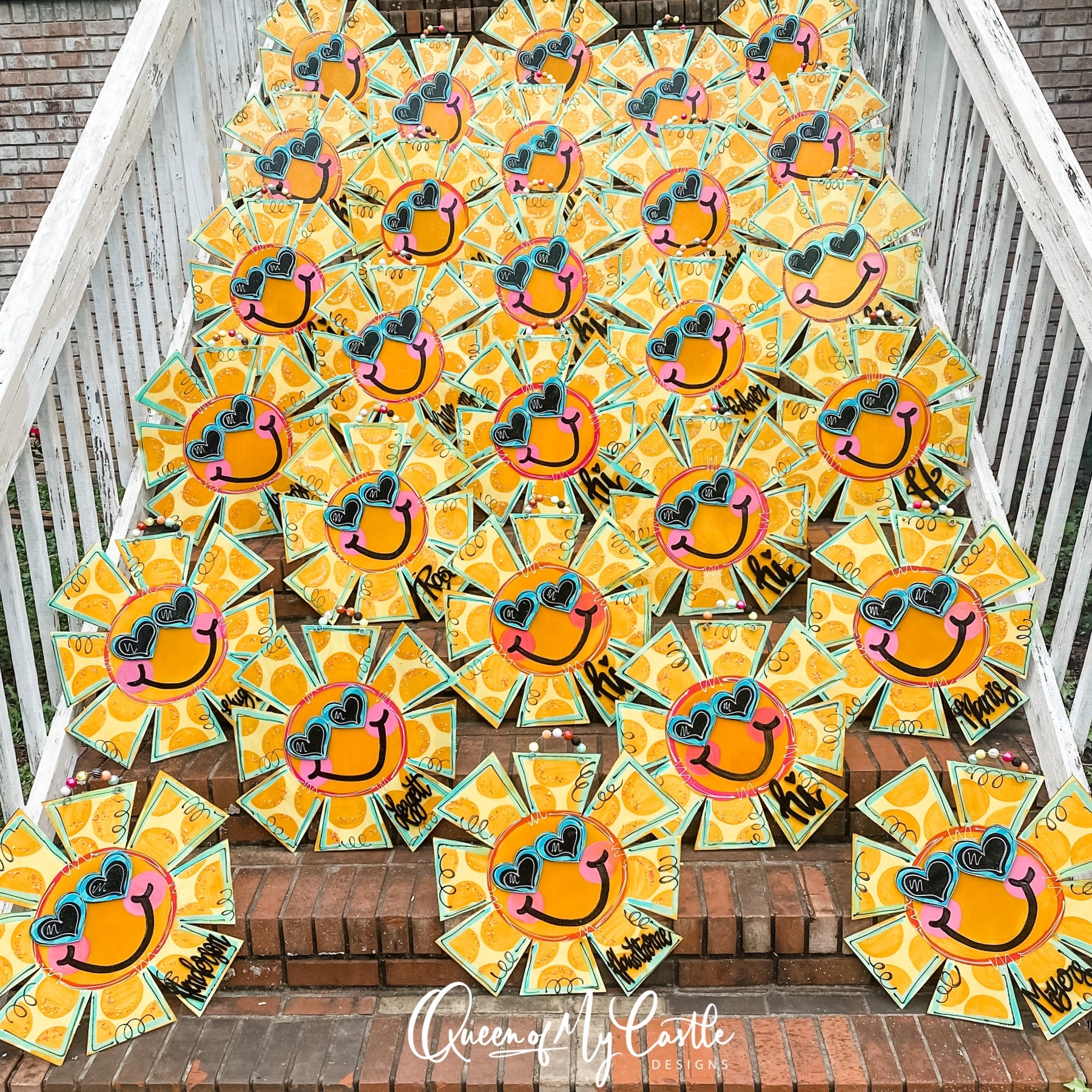 Many sun-shaped door hangers propped against steps.