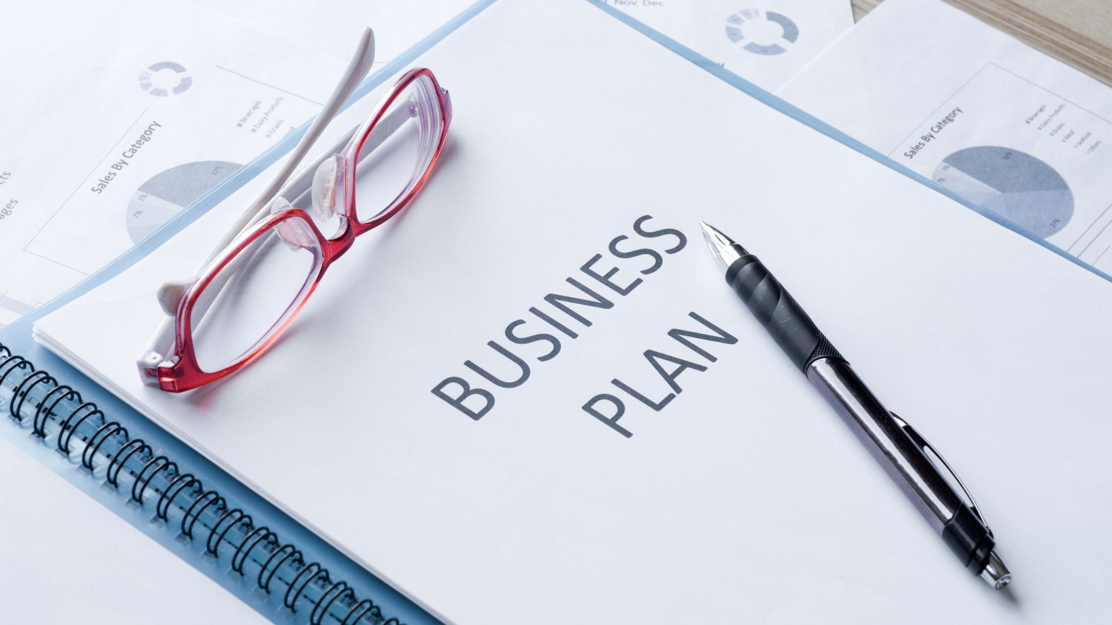 Business plan notebook with pen and glasses