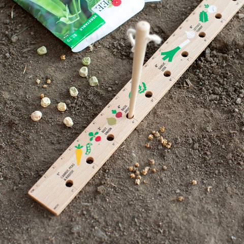 A seeding ruler is used for spacing and planting seeds evenly in the garden or seed trays