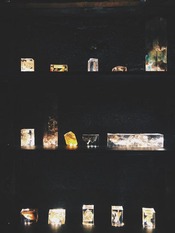 fragrances frozen in time and held within encapsulating resin blocks lined up on dark shelves almost with light coming from within