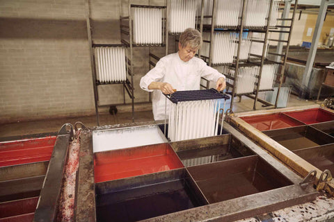 Ester, getting ready to dip white candles into coloured wax