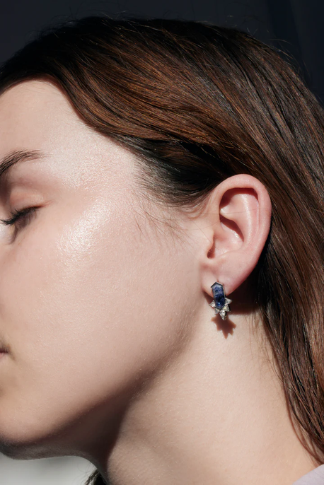 Sideview of a model showcasing stunning sapphire earrings gracefully adorning her ear