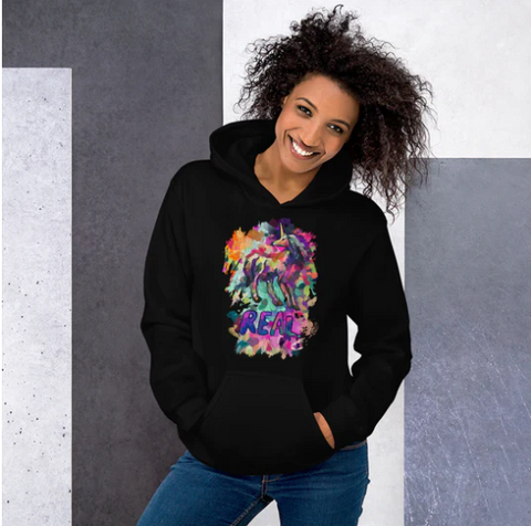 A woman wearing a Real Unicorn Apparel hoodie from the Real Unicorn clothing line.