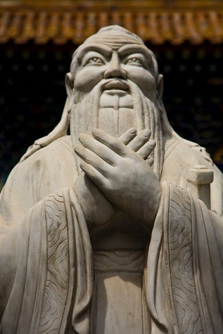 A photograph of a concrete statue of Confucius, the wise Chinese philosopher 