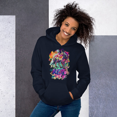 An attractive African-American woman with curly hair wearing a "Real Unicorn" Unisex Hoodie from Real Unicorn Apparel and a pair of form-fitting blue jeans.