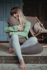 Girl hugging a moon cushion which works as a gravity cushion to stimulate the deep pressure