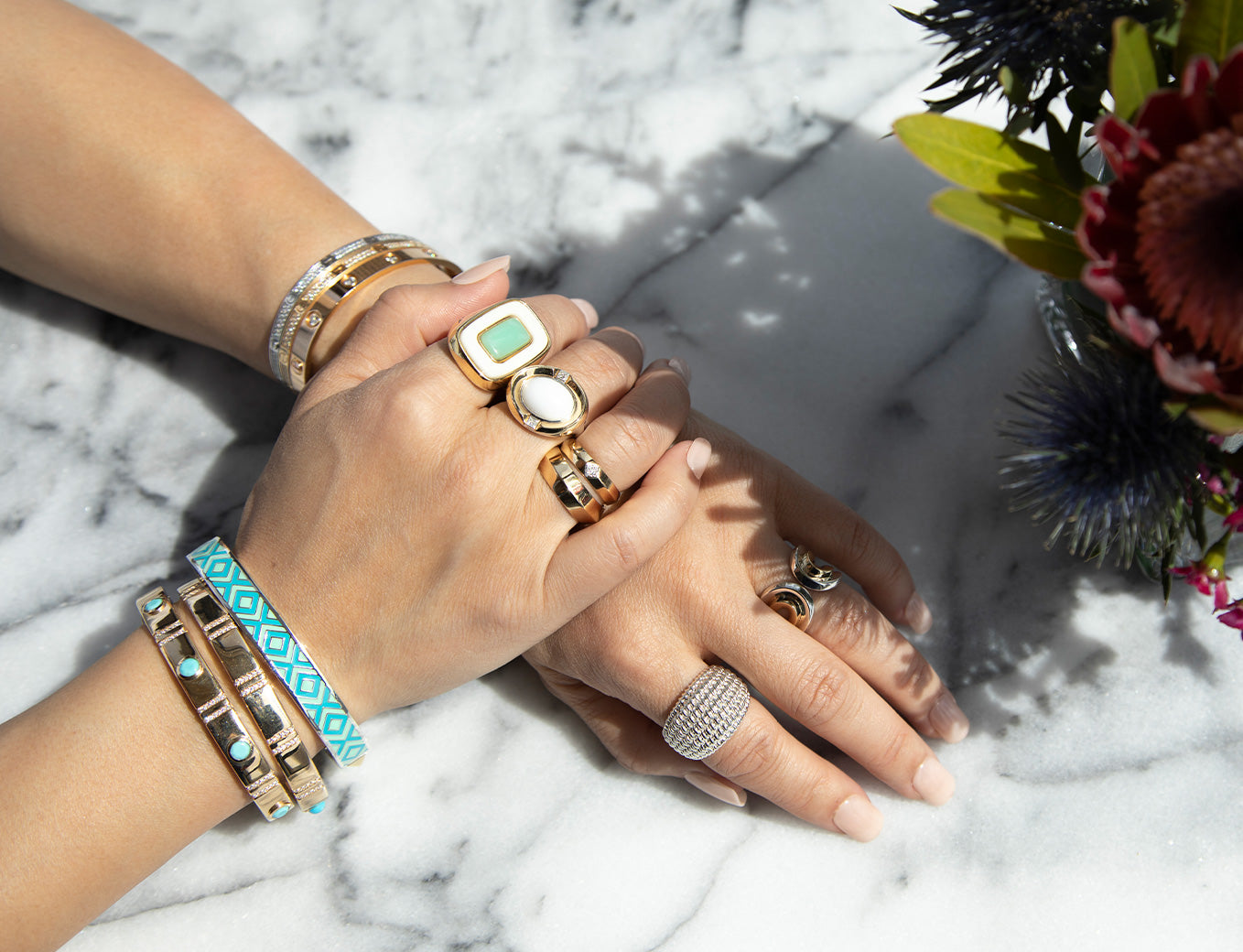 Close up of Kathy Fang's hands wearing a variety of Cast Jewelry rings and bracelets