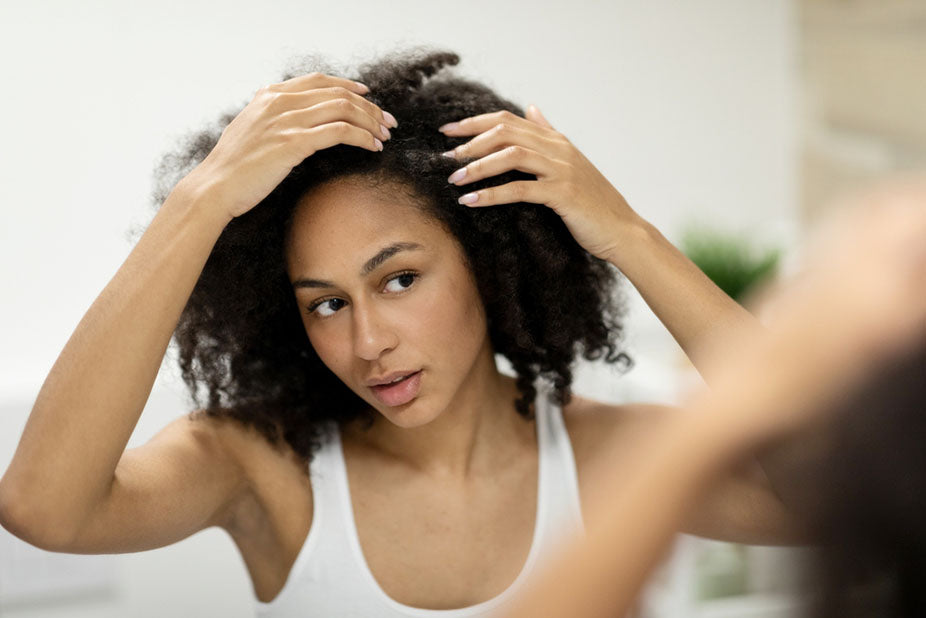 portrait of woman examining her scalp