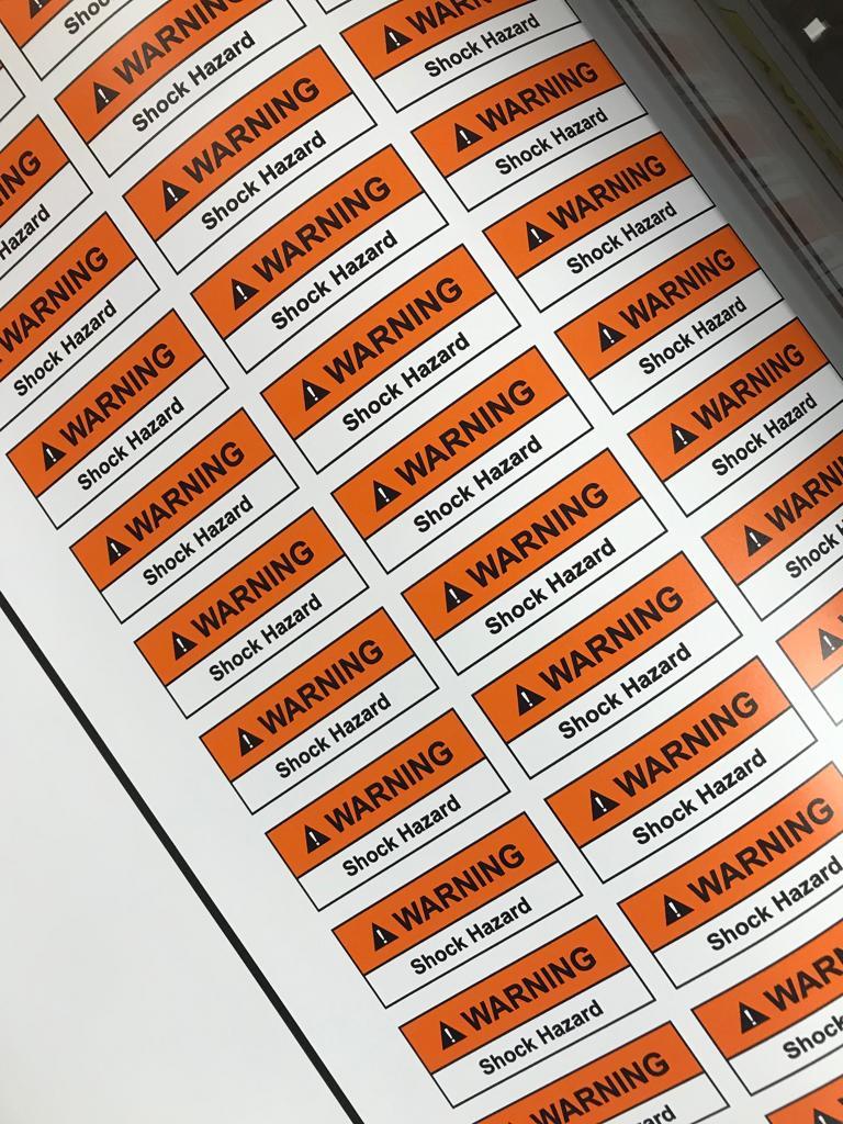 Orange and Black warning sticker displaying hazard symbol and cautionary message, ensuring workplace safety and compliance