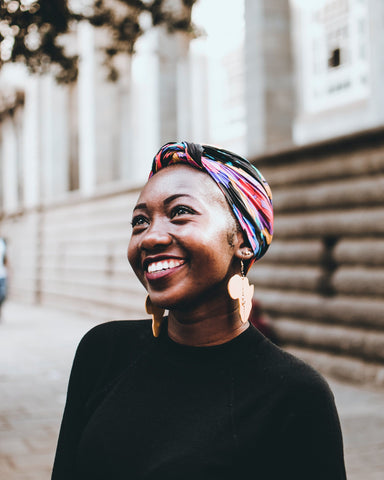 smiling woman wearing african wooden earrings